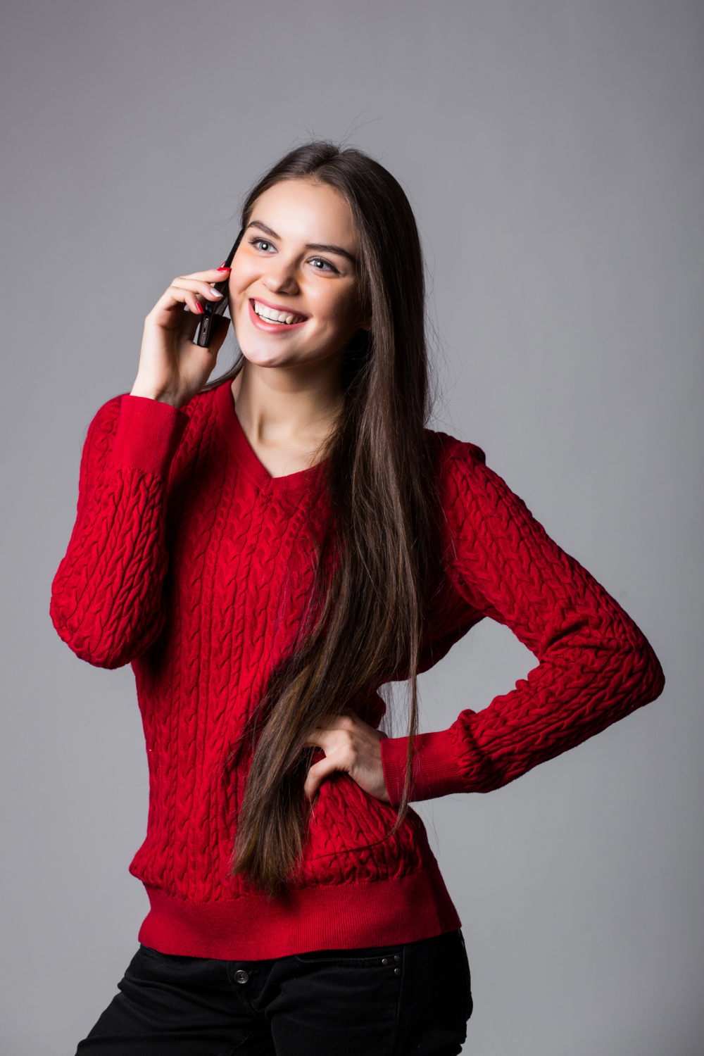 smiling-young-woman-talking-cell-phone-looking-up-blank-copy-space-white-wall